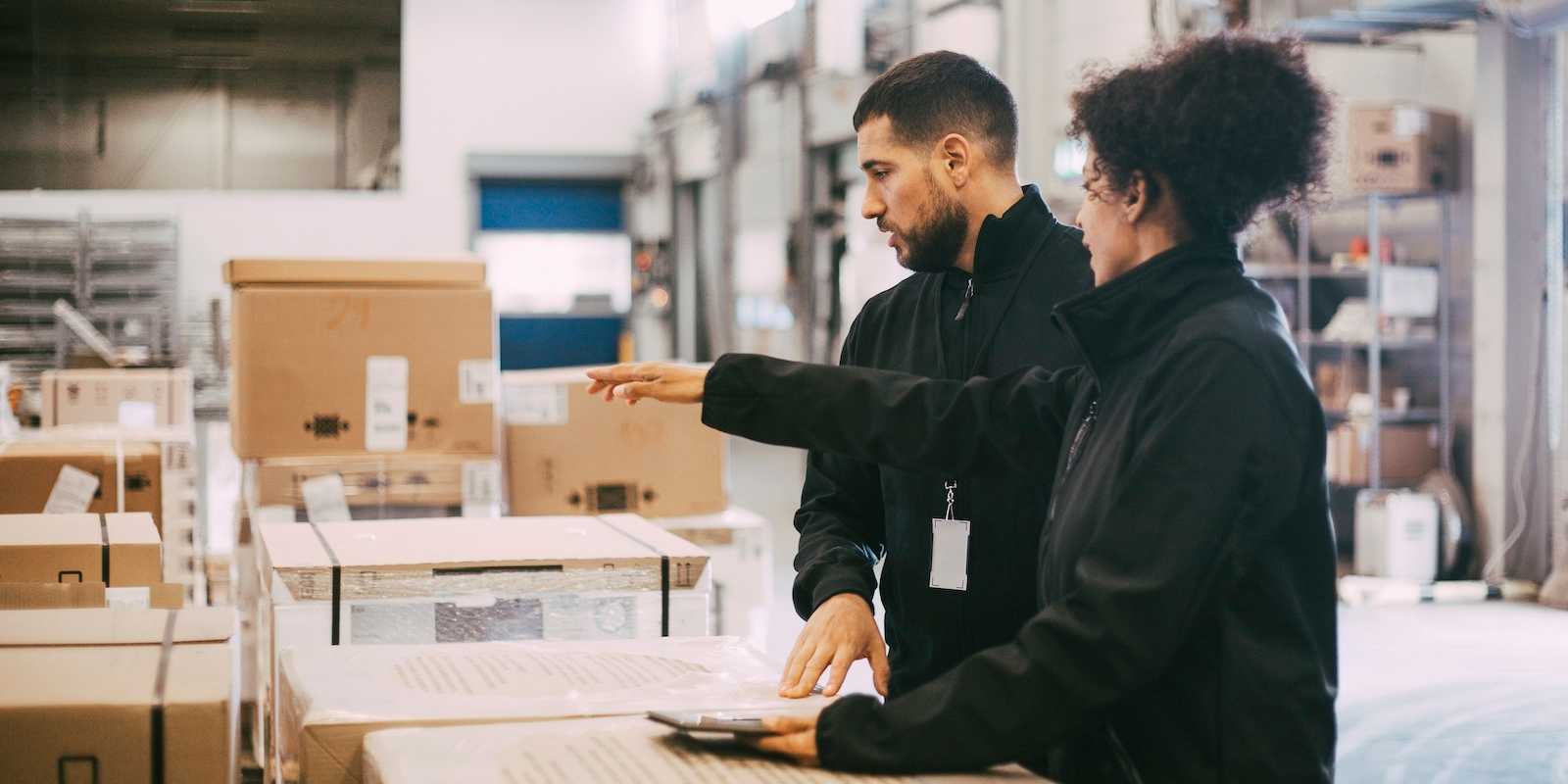Two warehouse workers accounting for deliveries