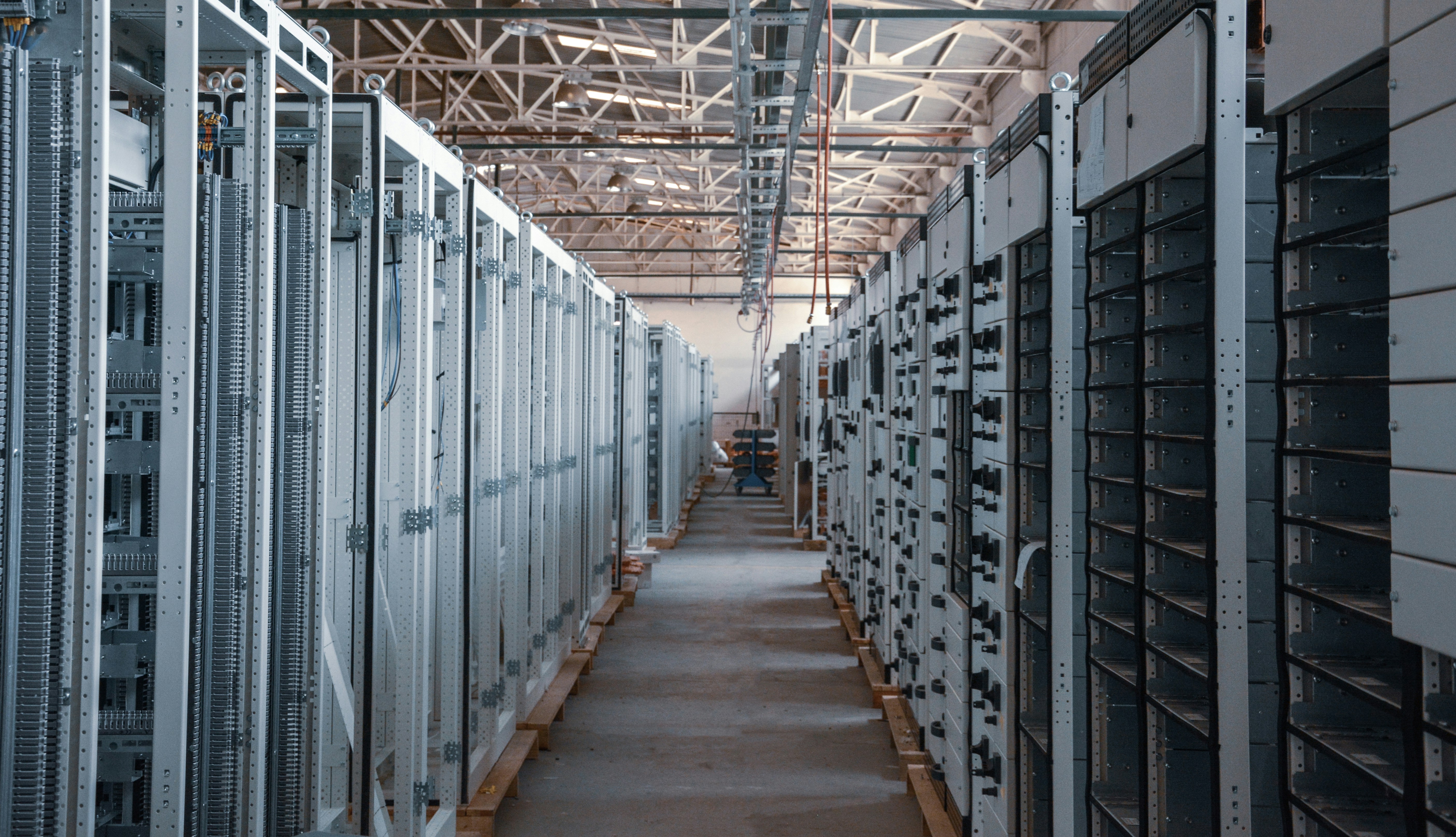 Rows of server cabinets lining the aisle of a data center facility