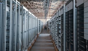 Rows of server cabinets lining the aisle of a data center facility