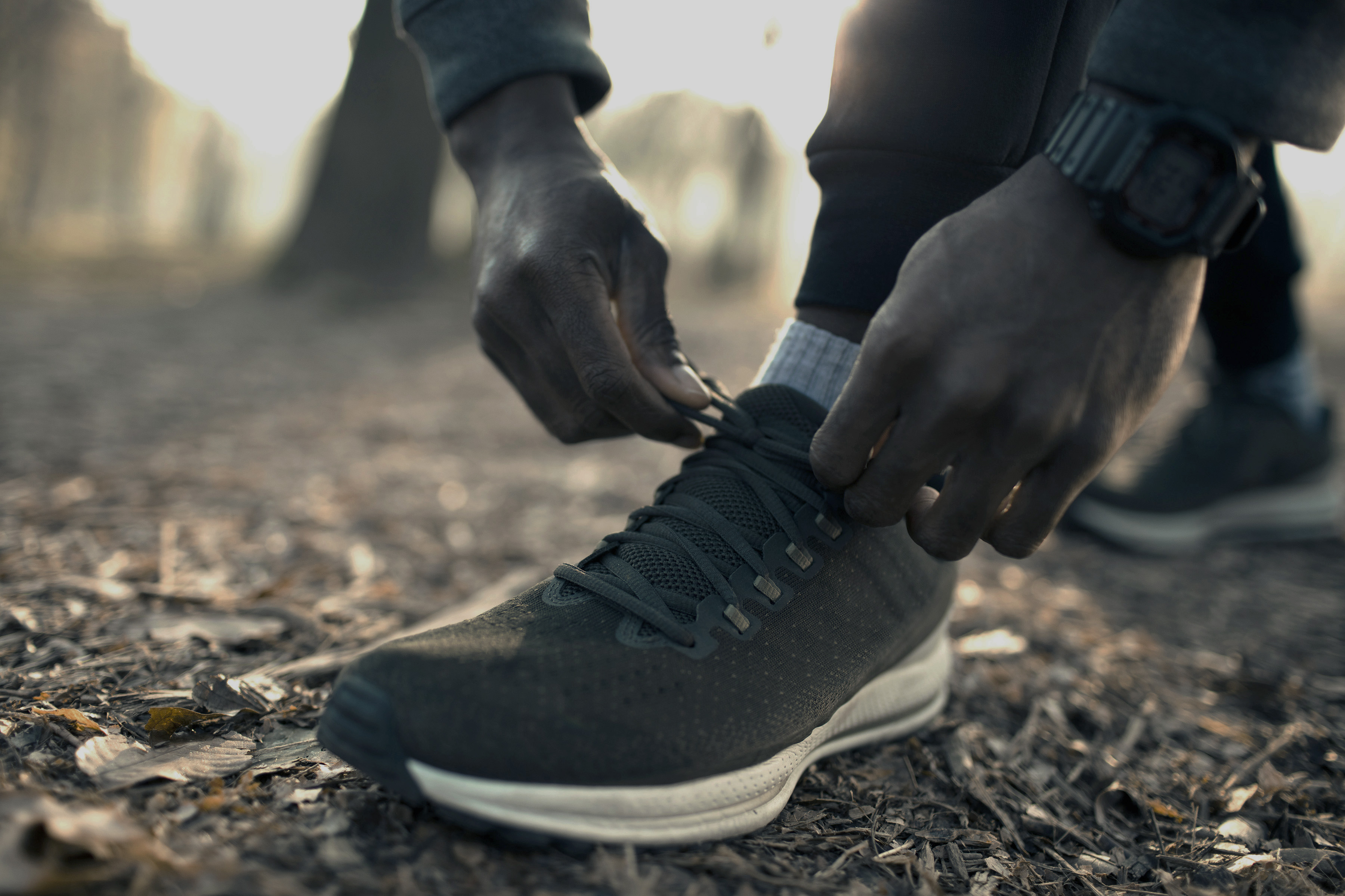 Close-up of a person tying the laces on a running shoe outdoors