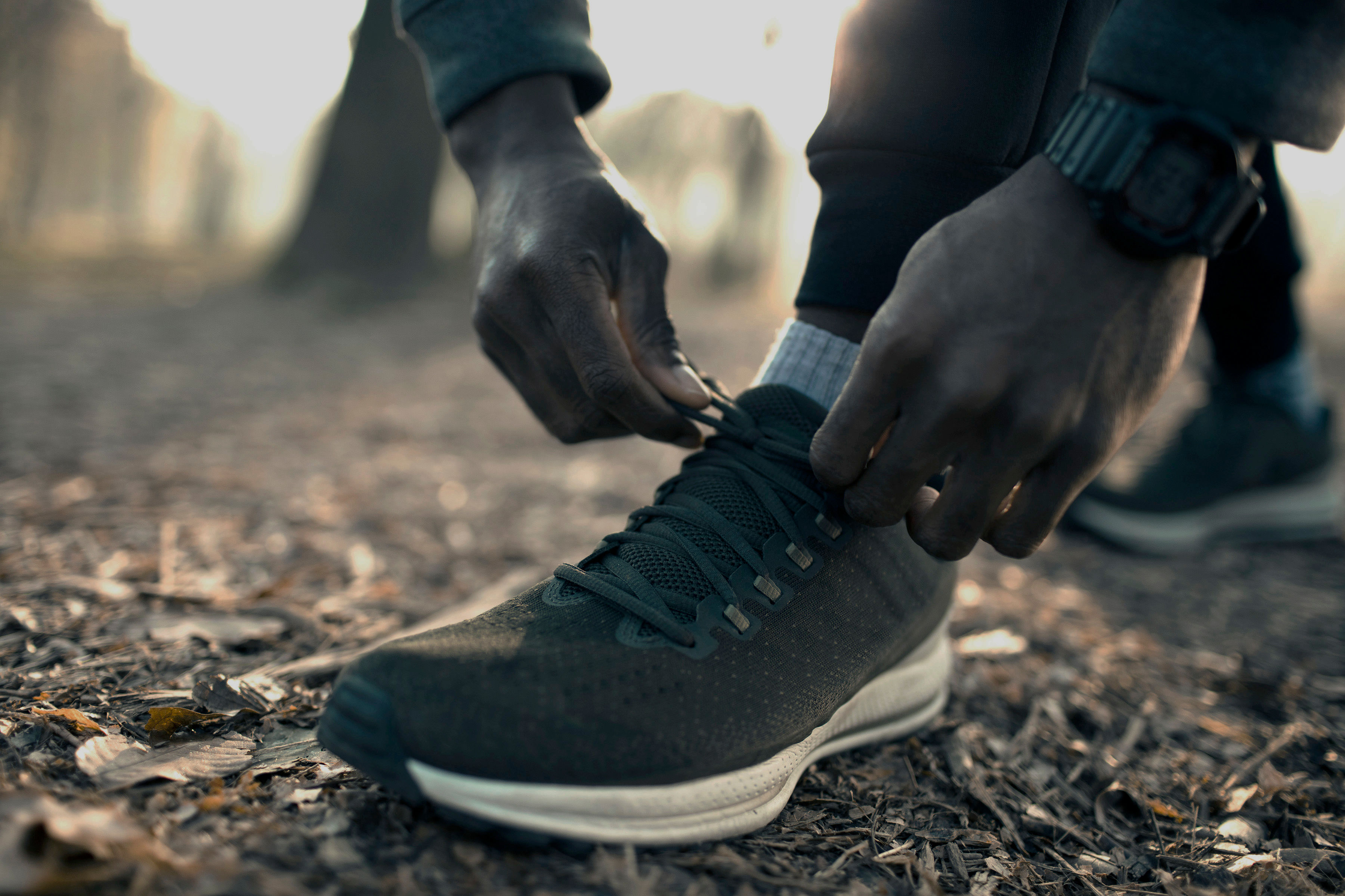 Close-up of a person tying the laces on a running shoe outdoors