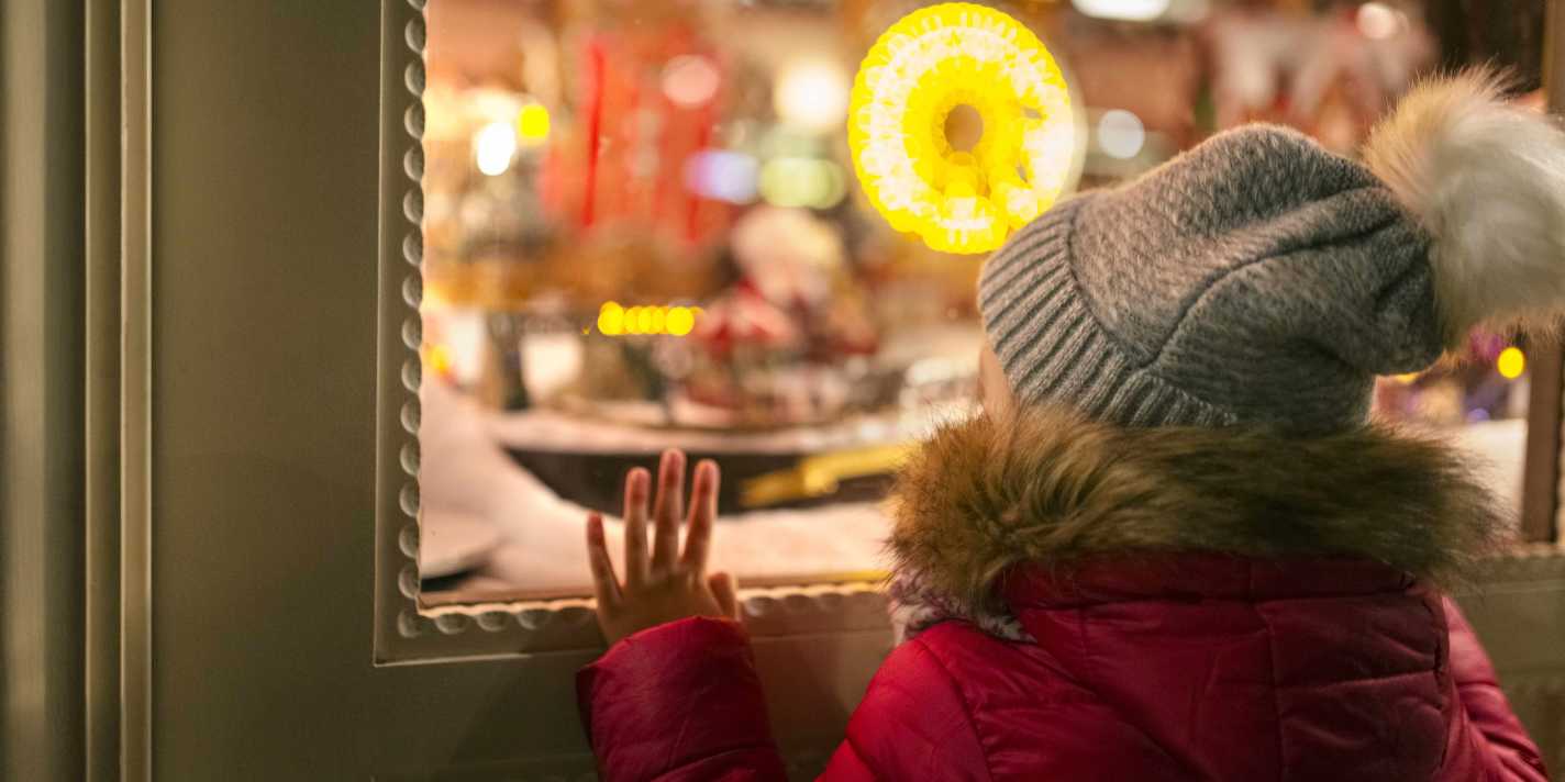 A child looks through the window of the store during the holiday shopping season.