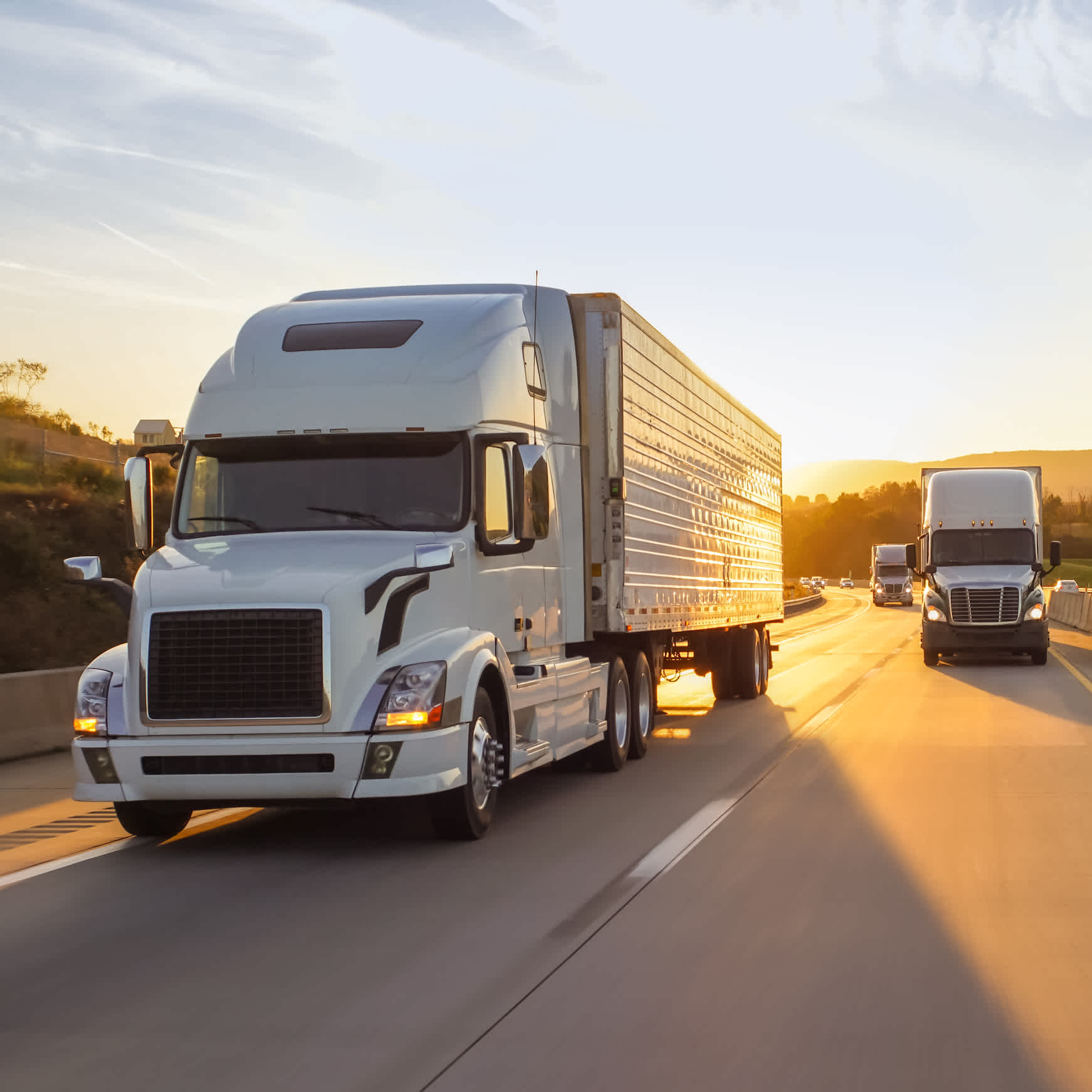 Trucks driving toward camera during sunset