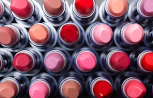 Overhead view of lipstick tubes arranged in rows of varied shades