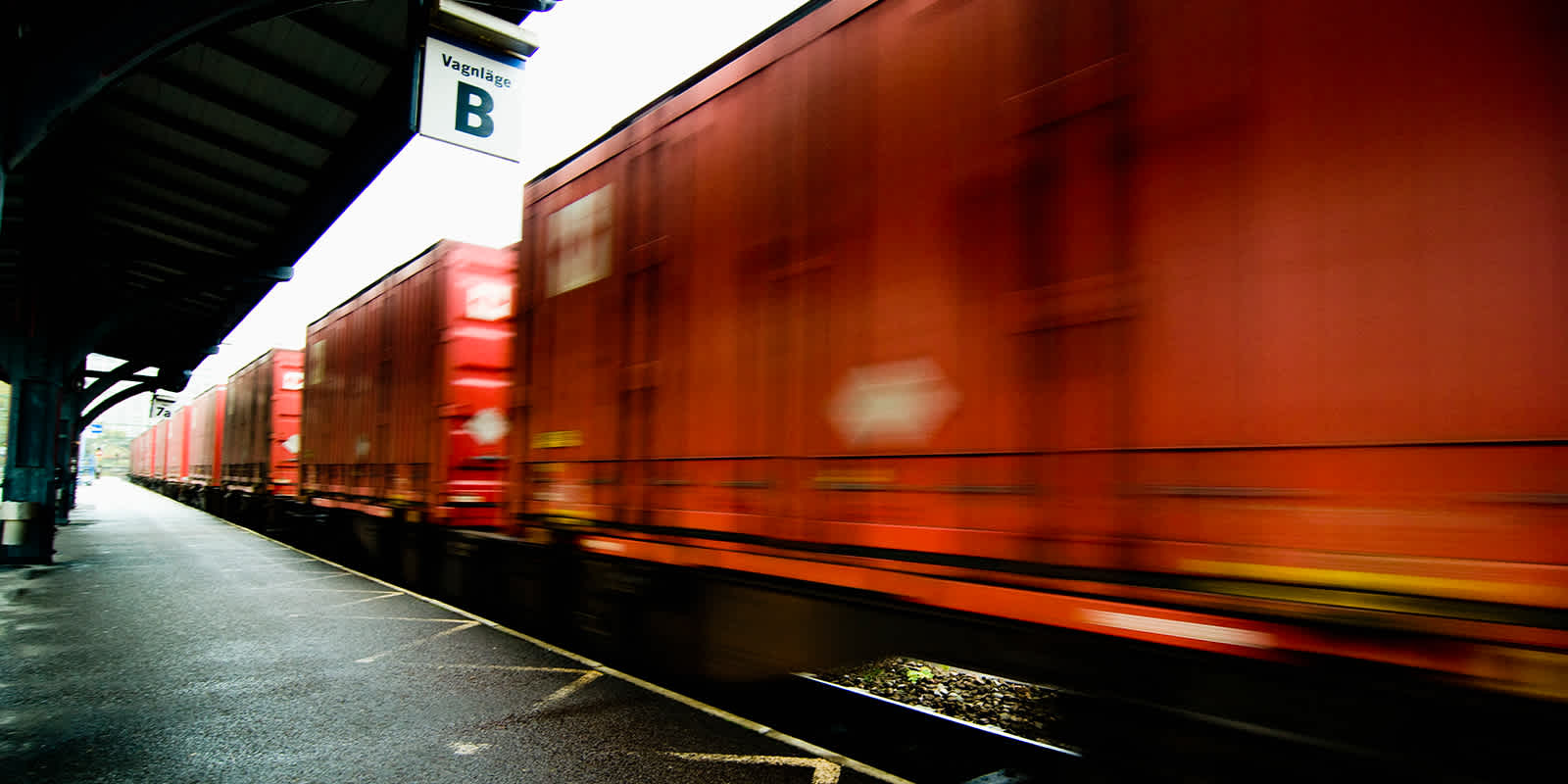 Image of containers on rail passing through a station
