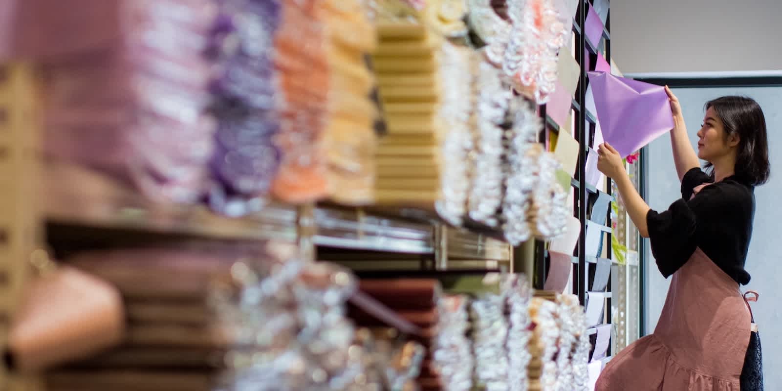 Apparel warehouse worker checking stock of fabric