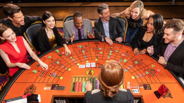 Group of people playing at Baccarat table