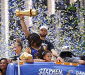 Golden State Warriors guard Stephen Curry holds the NBA Finals Most Valuable Player Award trophy during the Warriors championship parade