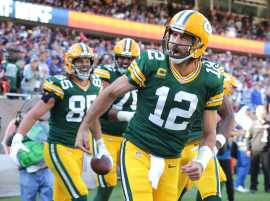 Packers quarterback Aaron Rodgers (12) celebrates his rushing touchdown during the fourth quarter of the Green Bay Packers 24-14 win at Soldier Field.
