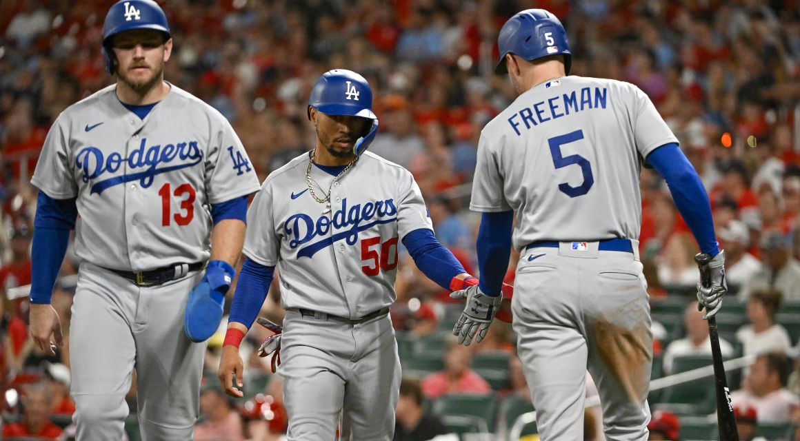 os Angeles Dodgers third baseman Max Muncy (13) and right fielder Mookie Betts (50) celebrate with first baseman Freddie Freeman (5) after they both scored on a single by shortstop Trea Turner (not pictured) against the St. Louis Cardinals during the eighth inning at Busch Stadium. Mandatory Credit: Jeff Curry-USA TODAY Sports.