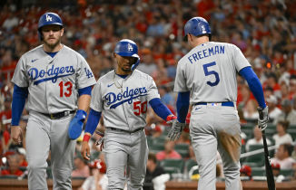 os Angeles Dodgers third baseman Max Muncy (13) and right fielder Mookie Betts (50) celebrate with first baseman Freddie Freeman (5) after they both scored on a single by shortstop Trea Turner (not pictured) against the St. Louis Cardinals during the eighth inning at Busch Stadium. Mandatory Credit: Jeff Curry-USA TODAY Sports.