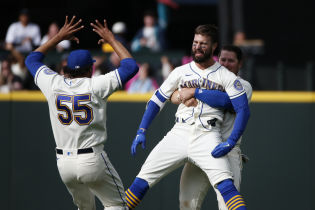 Seattle Mariners right fielder Jesse Winker (27) is hugged by third baseman Ty France (23, right) after hitting a walk-off RBI-single against the Kansas City Royals during the twelfth inning at T-Mobile Park. Seattle defeated Kansas City, 5-4. Mandatory Credit: Joe Nicholson-USA TODAY Sports.