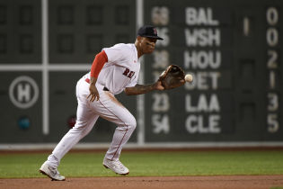 Boston Red Sox third baseman Rafael Devers (11) fields a ground ball during the first inning against the New York Yankees at Fenway Park.
