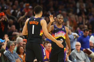 Phoenix Suns guard Devin Booker (1) and guard Chris Paul (3) celebrate the victory against the Philadelphia 76ers at Footprint Center. Mandatory Credit: Mark J. Rebilas-USA TODAY Sports.