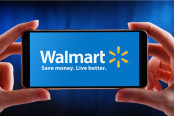 Hands holding smartphone displaying logo of Walmart Inc