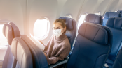 woman wearing face mask is traveling on airplane