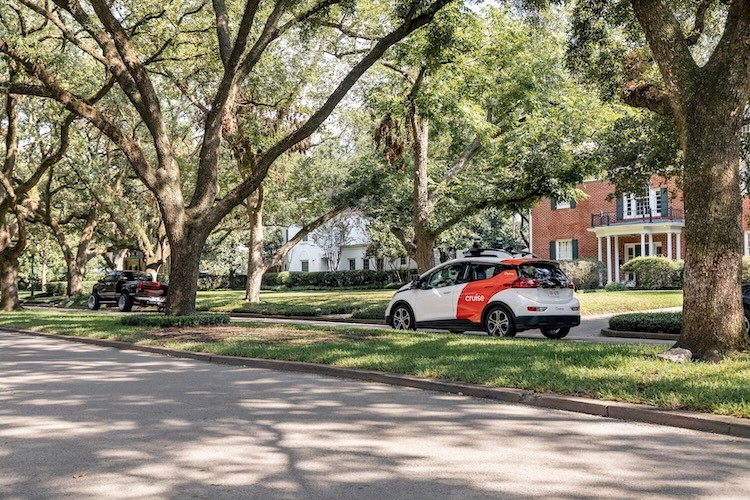 Cruise vehicle driving in neighborhood with parked cars cover