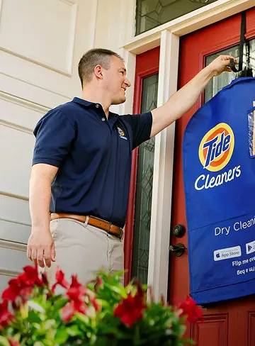 Empleado de Tide Cleaners entregando ropa limpia a domicilio.