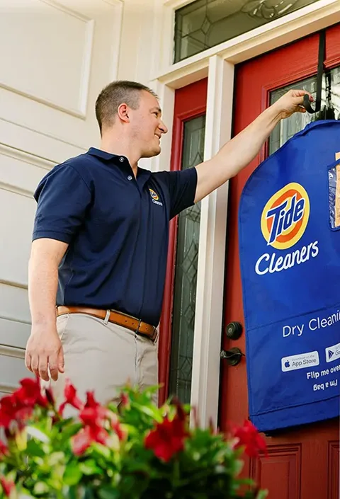 Empleado de Tide Cleaners entregando ropa limpia a domicilio.