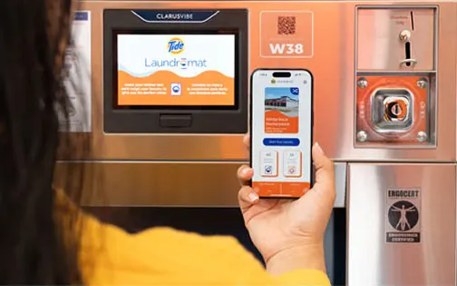 Persona usando la app de Lavandería Tide para pagar una máquina y ver recompensas.
