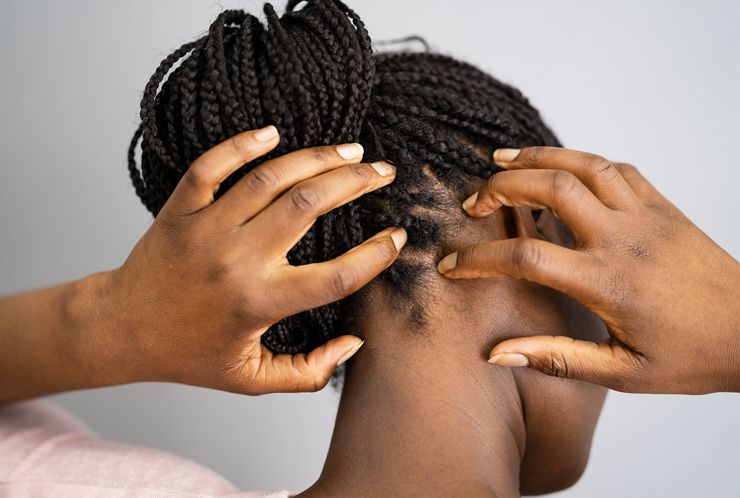 African-American woman with braids scratching the back of her itchy scalp. African-American woman with braids scratching the back of her itchy scalp.