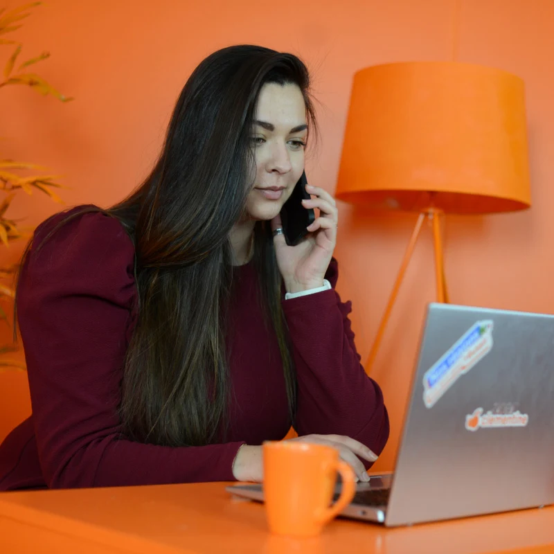 Photo d'un comptable en rendez-vous avec un client dans une salle entièrement orange