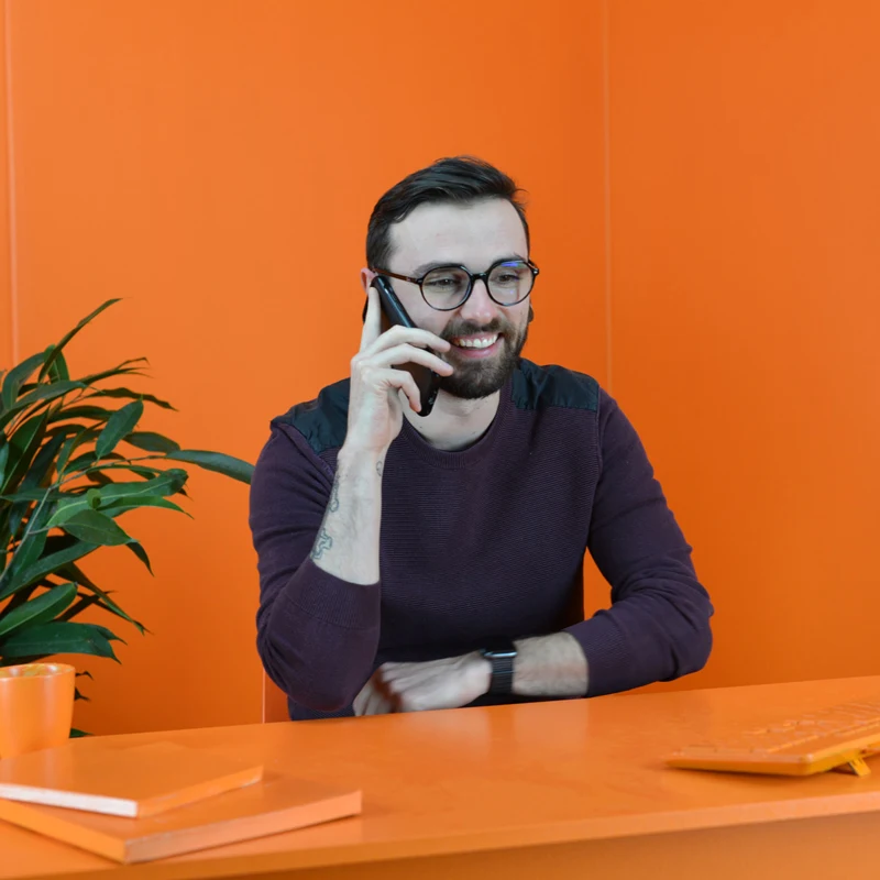 Photo d'un comptable en rendez-vous avec un client dans une salle entièrement orange