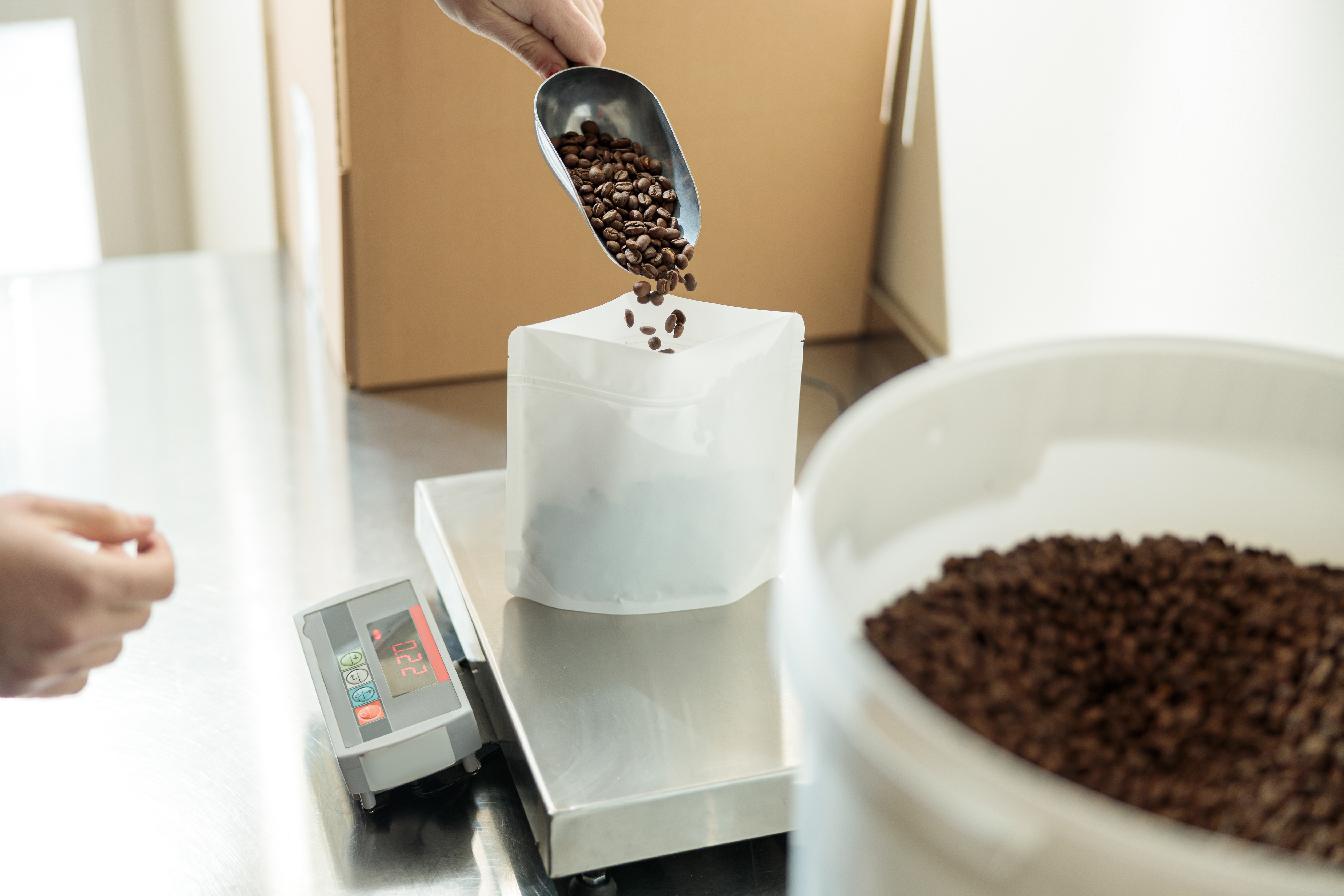 Coffee beans added to scale for weighing