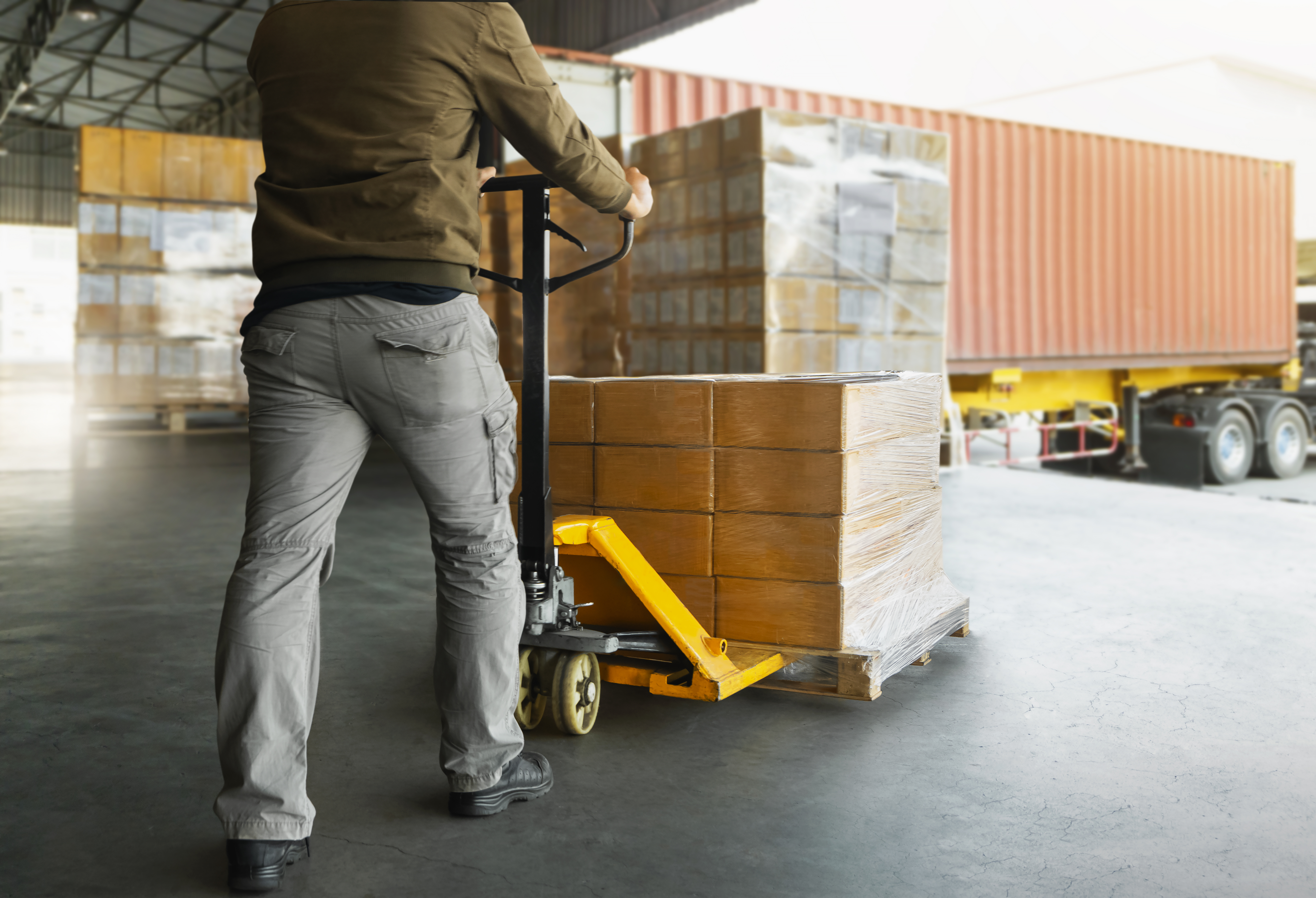 inventory manager loading a pallet of products onto a cargo truck