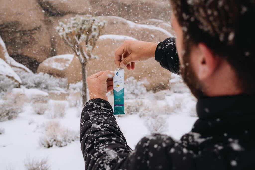Hydration Multiplier stick being opened in the snow. 