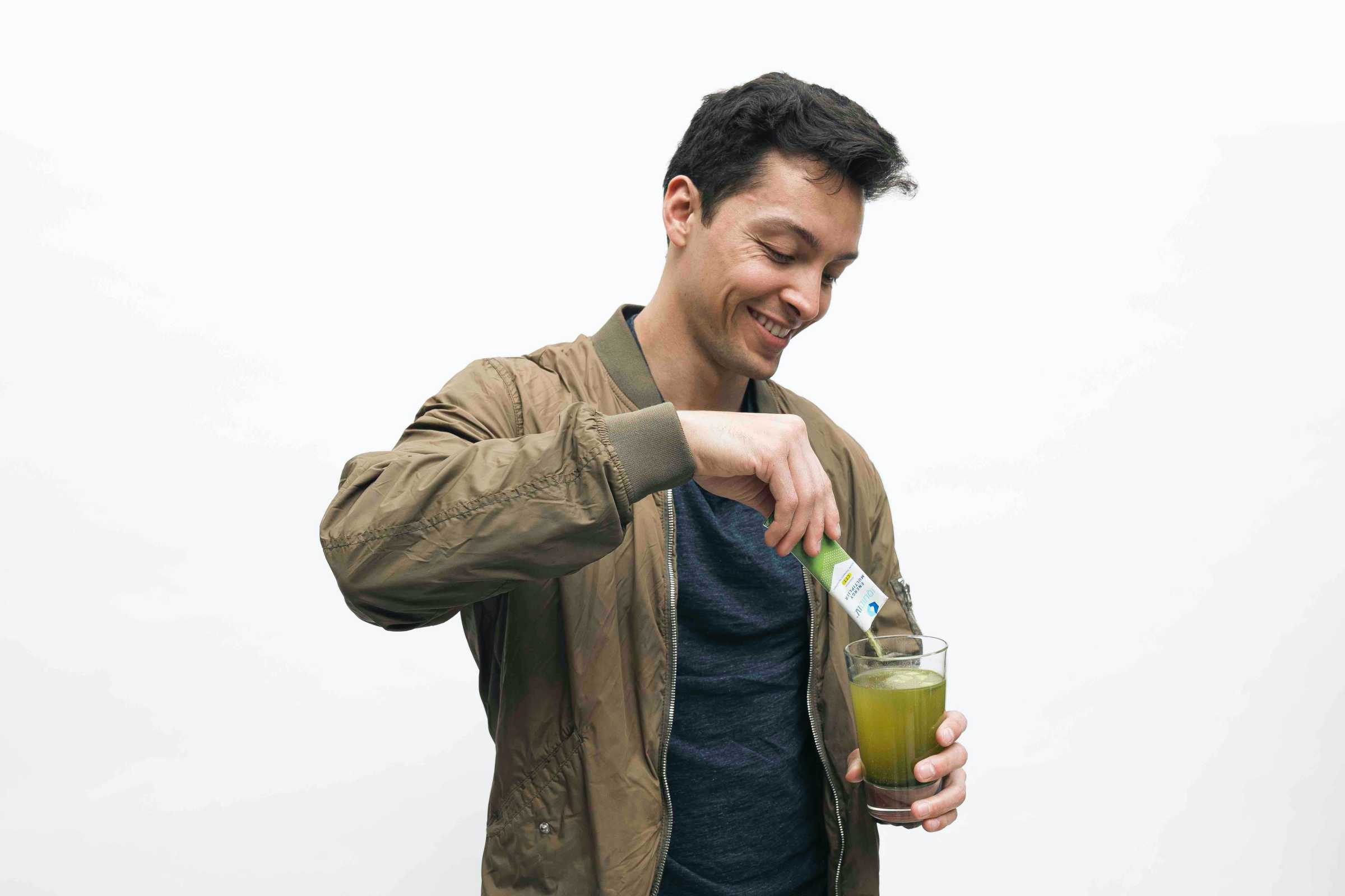 Man pours Liquid I.V. Energy Multiplier into glass of water. 