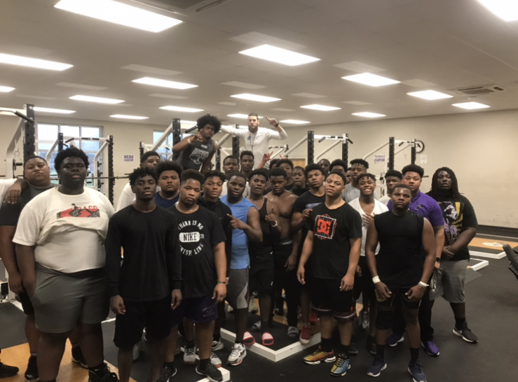 Parker high school football team poses in together in school gym. 