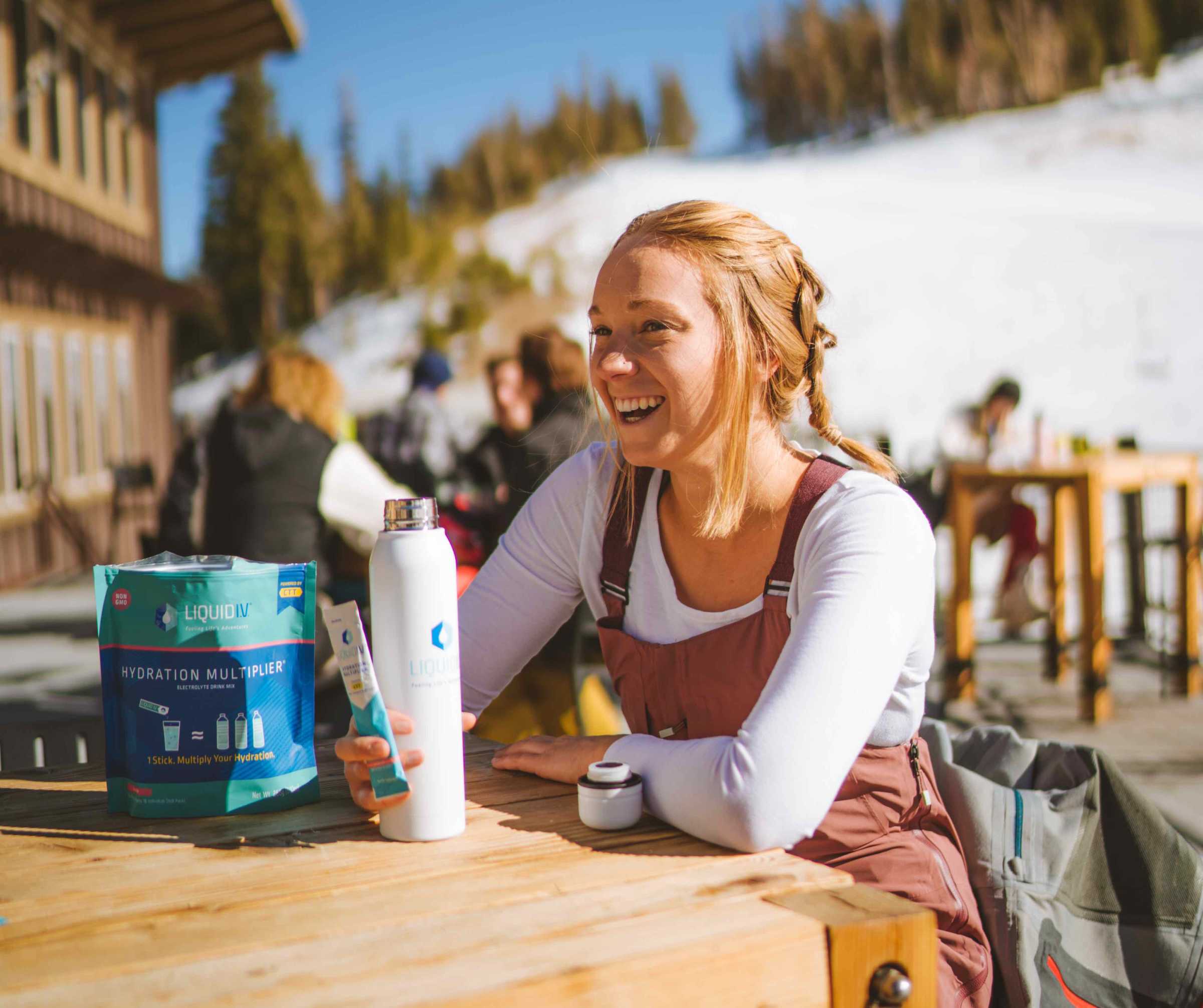 Happy young woman takes a break from skiing to hydrate with Liquid I.V. 