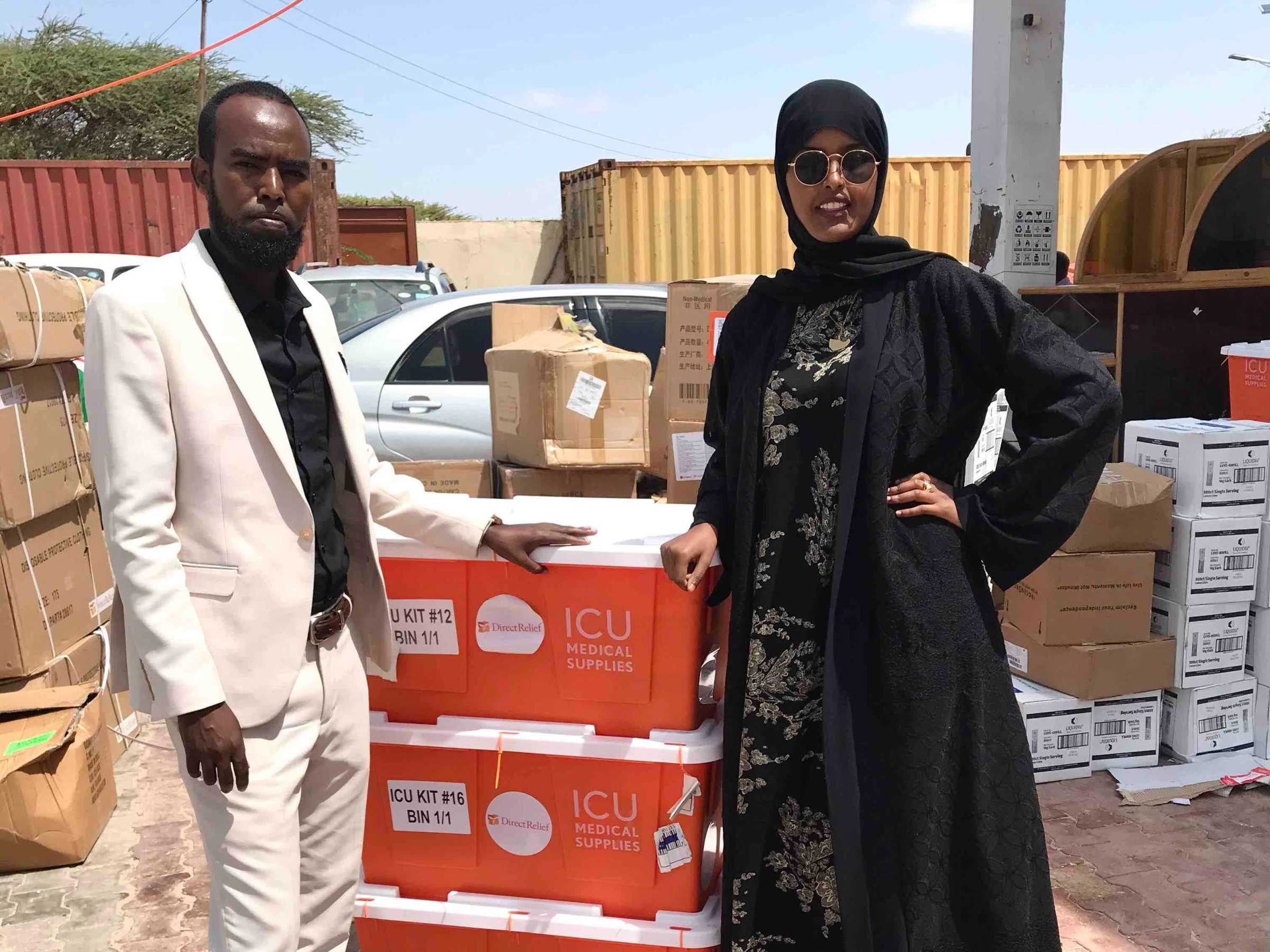 Young woman and man posing with ICU kits and donations of Liquid I.V. Hydration Multiplier. 