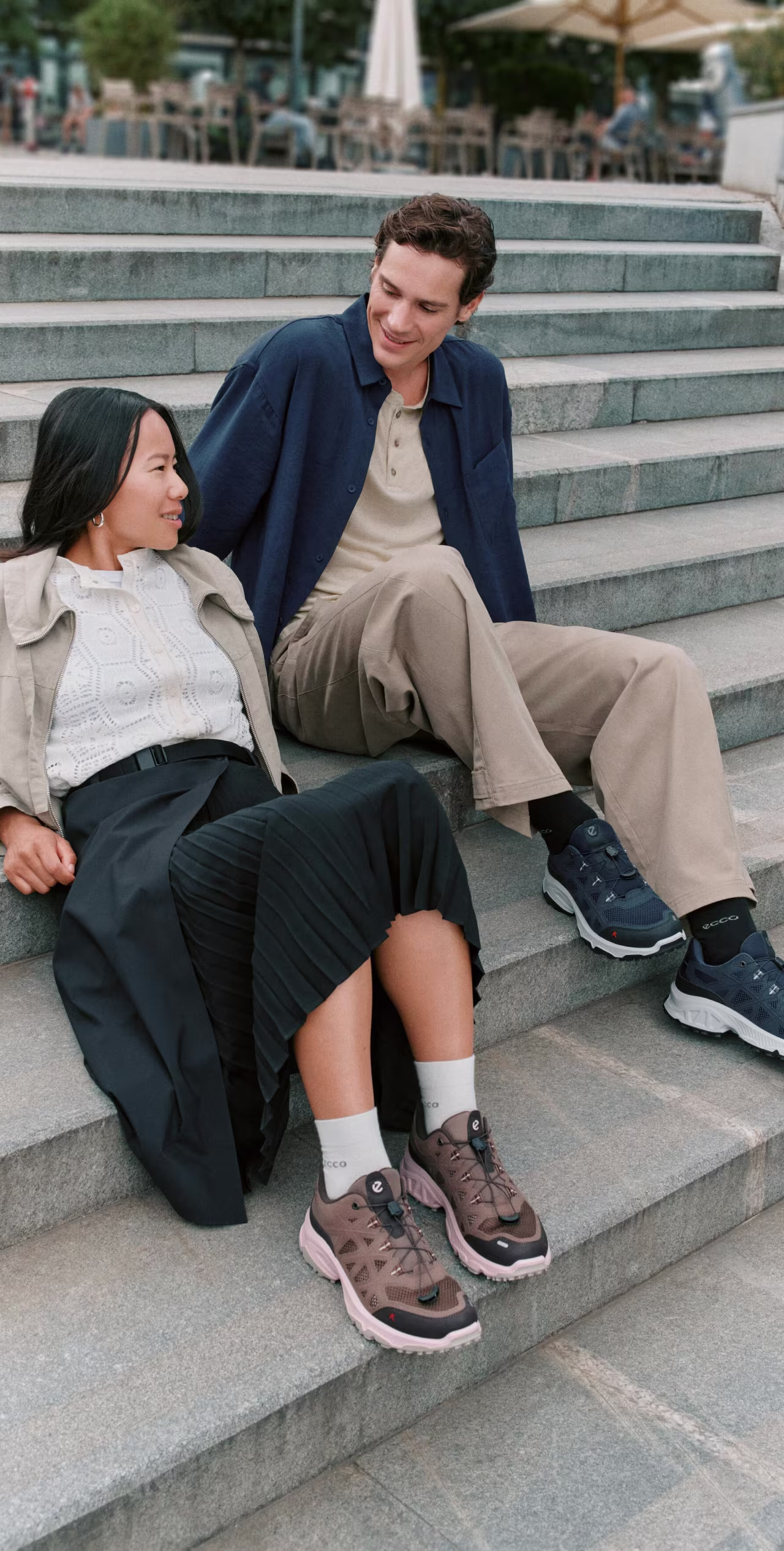ECCO Ult-Trn Receptor Breathru trainers worn by a couple sitting on stone steps