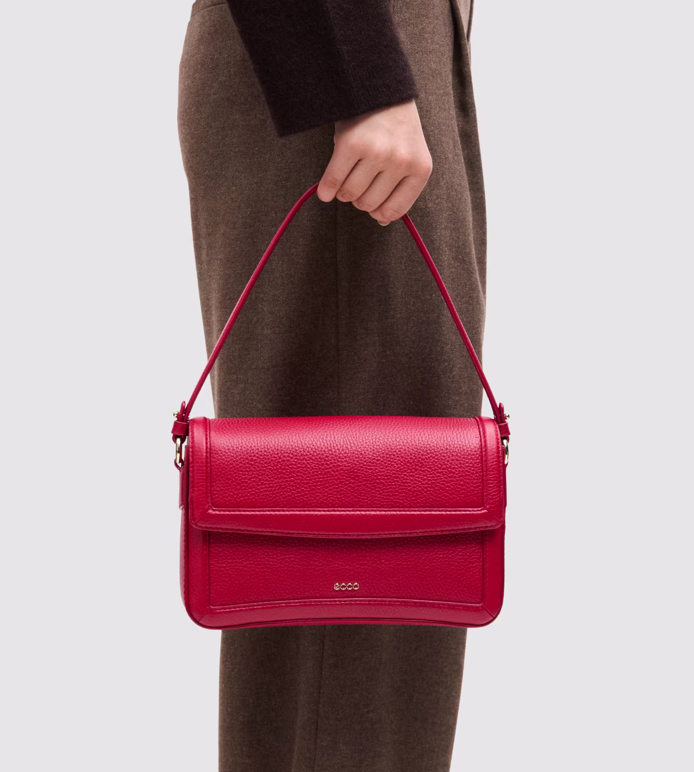Crafted from rich red pebbled leather, this vibrant shoulder bag seamlessly combines sleek Scandinavian minimalism with versatile daily functionality.