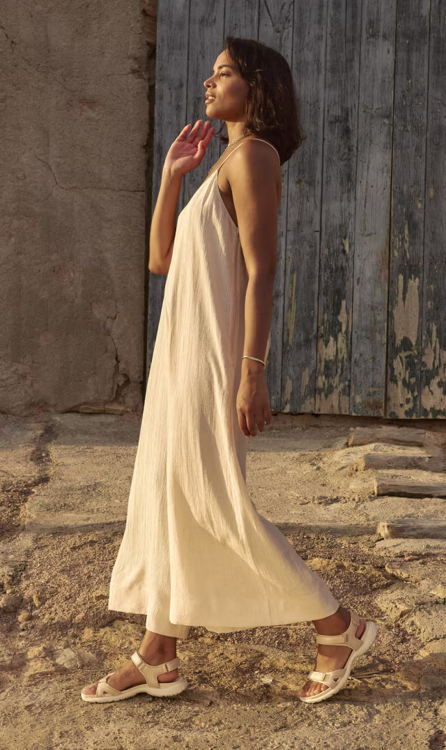ECCO Offroad Roam women's beige leather sports sandals, styled with a light linen jumpsuit against a blue wooden door.