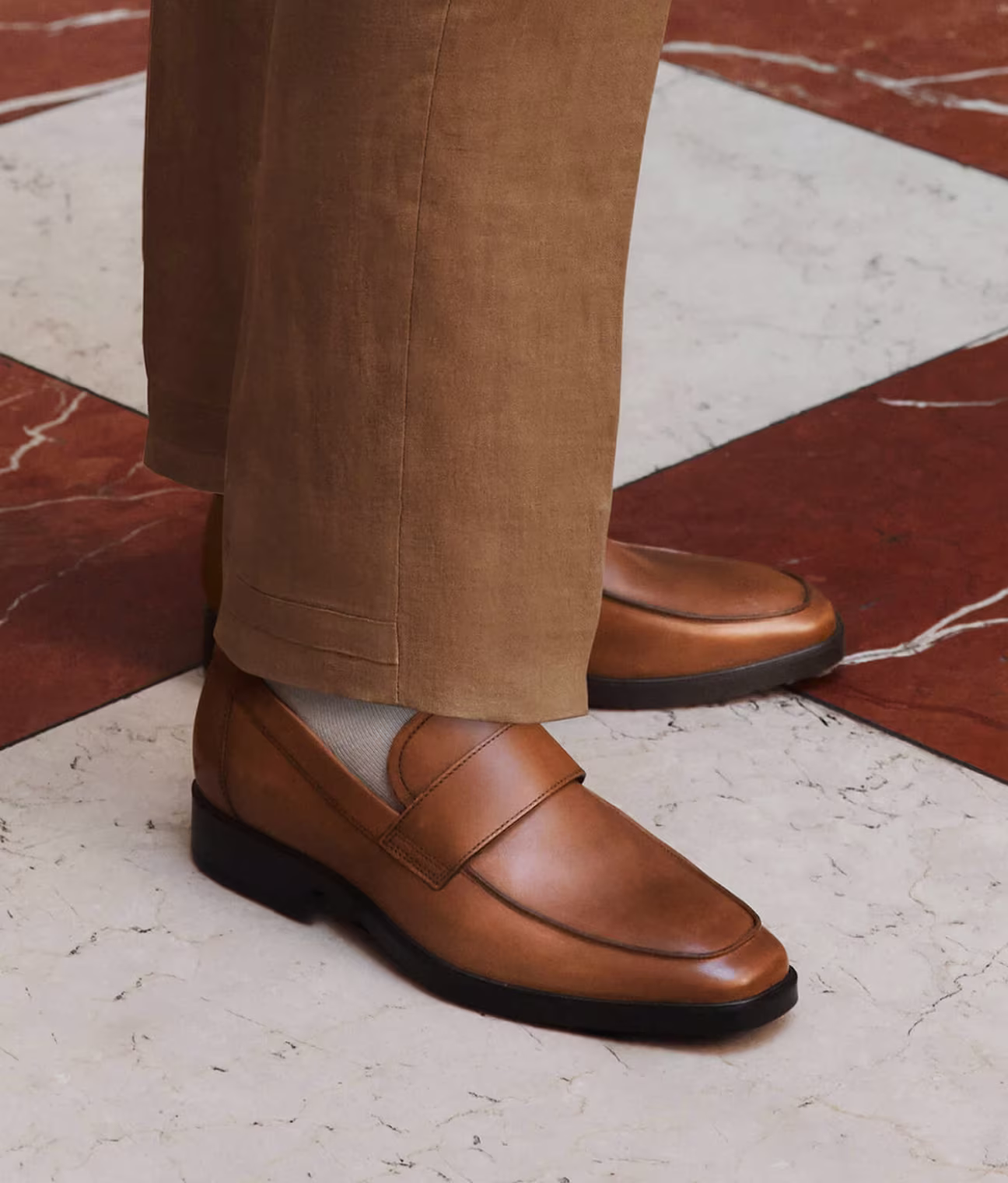Dezente Eleganz, definiert durch glattes, hochwertiges hellbraunes Leder und eine klare Silhouette, die ein leichtes Tragegefühl für müheloses saisonales Styling bietet.