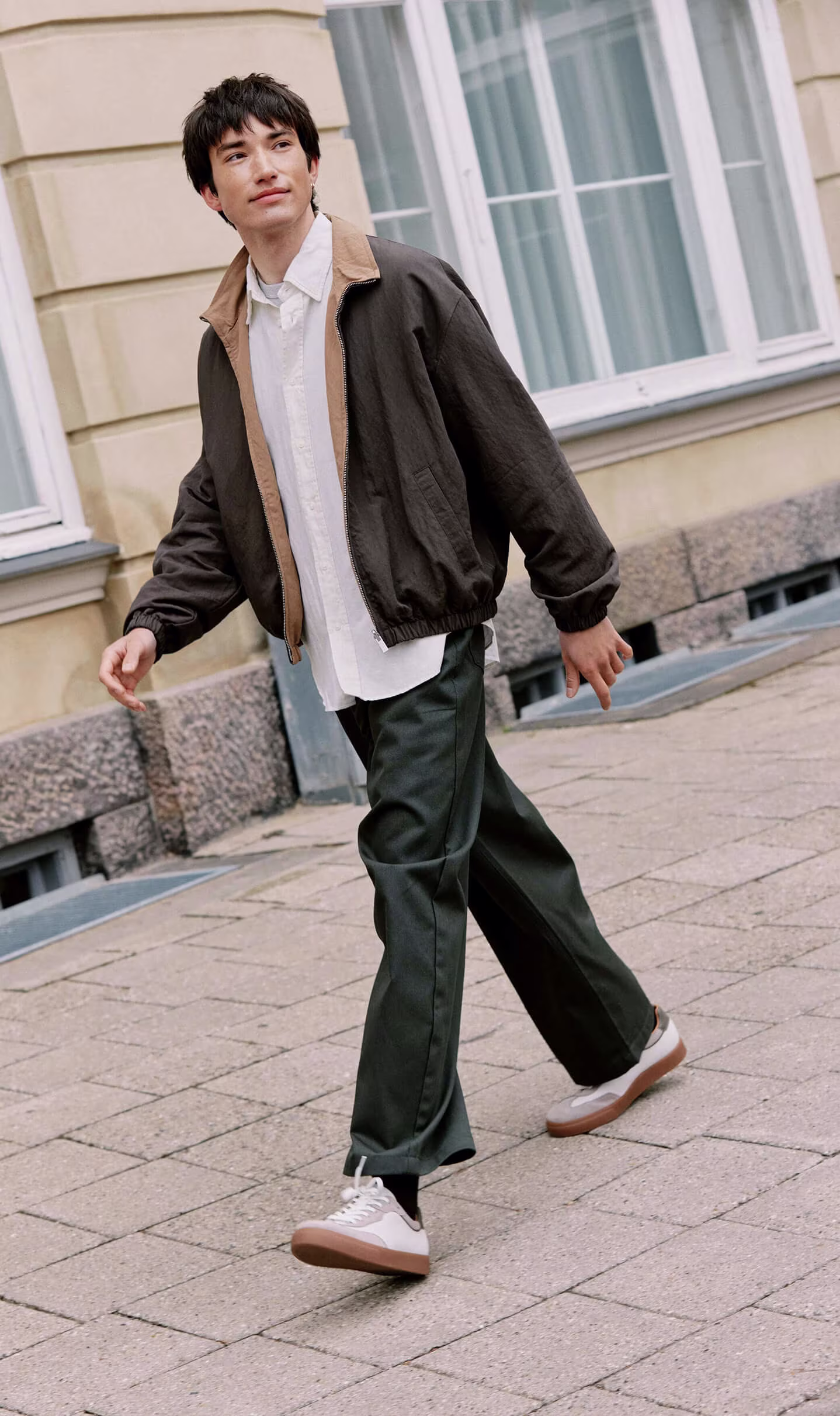 Man walking outdoors wearing ECCO white and grey leather lace-up casual sneakers with gum rubber soles