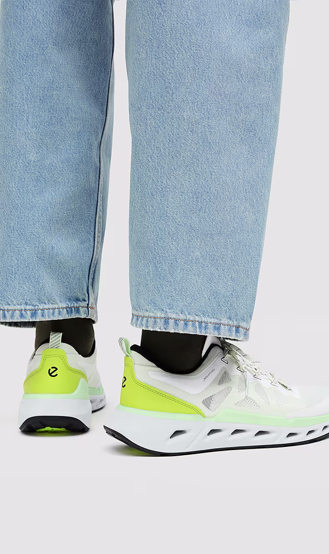 Zbliżenie na męskie sneakersy sportowe ECCO Biom 720 v2 z oddychającej siateczki w kolorze białym z neonowo-zielonymi akcentami.