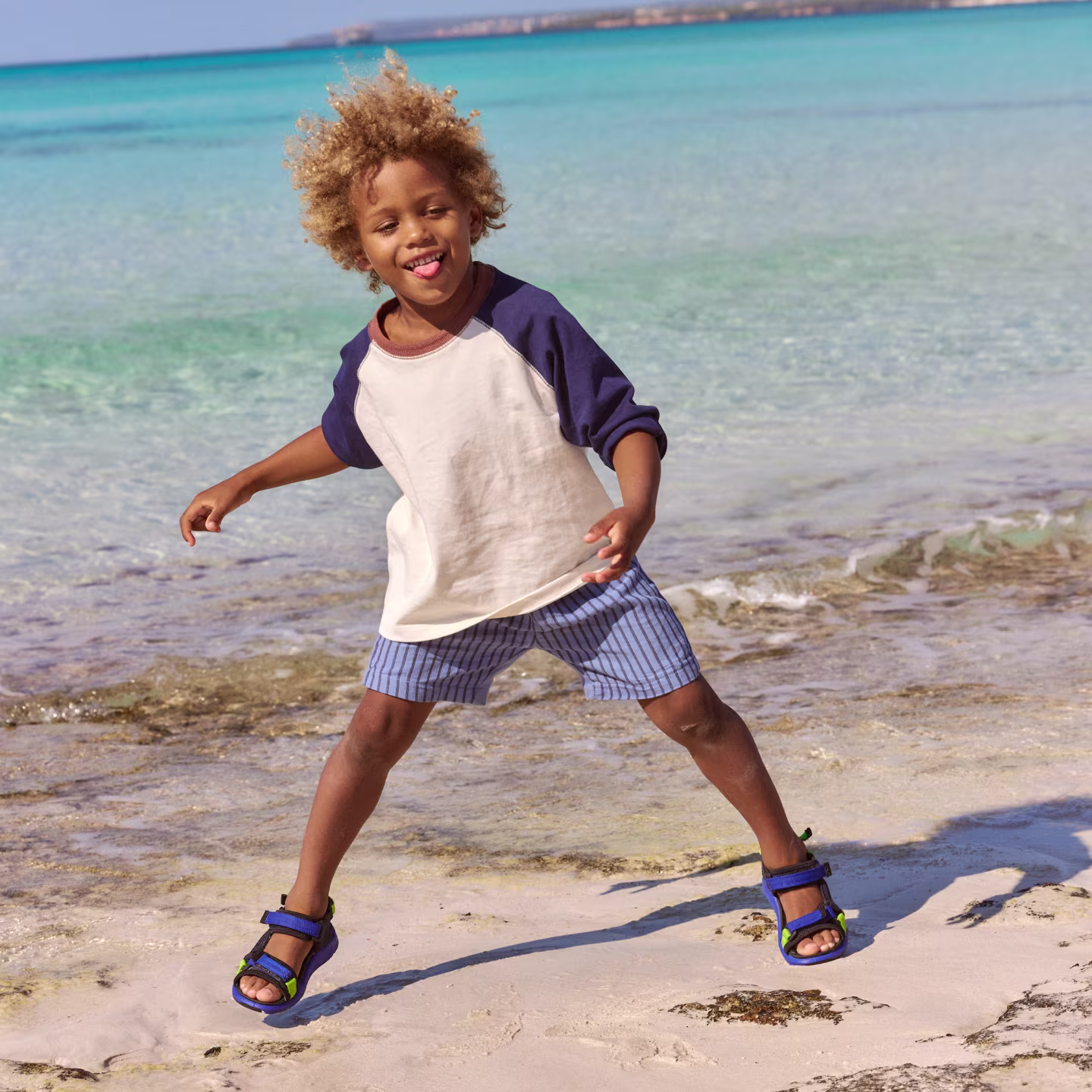 A boy wearing ECCO X-Trinsic Kids' Textile Sandals on the beach