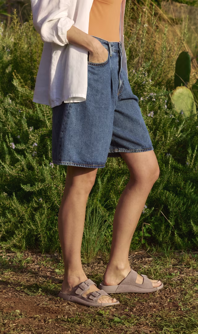 ECCO Cozmo, stilrena slip-in-sandaler för dam i taupefärgat nubuckläder med två remmar.