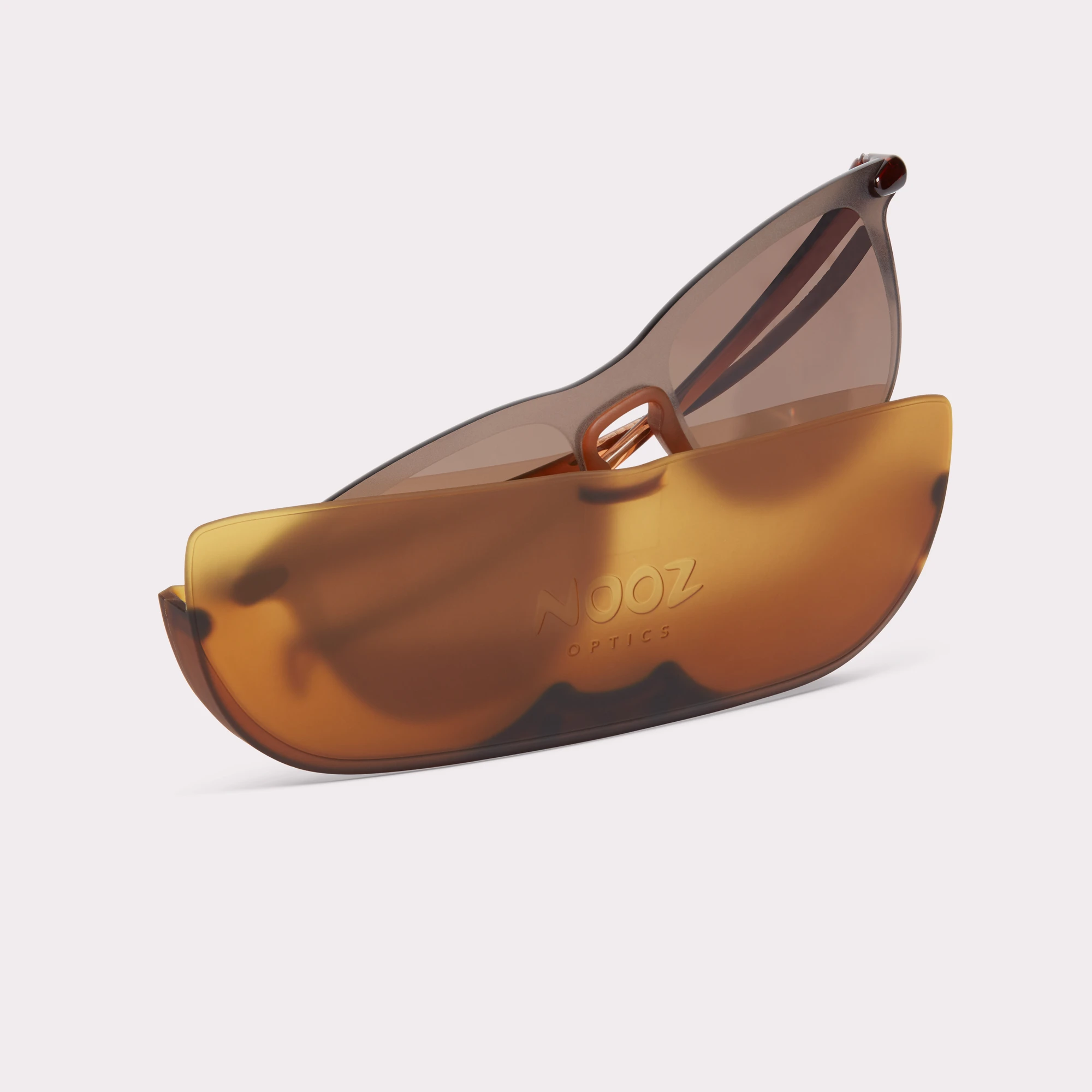 Een par Essential Sport Rechthoekig Bruin Zonnebril dat uit zijn etui komt