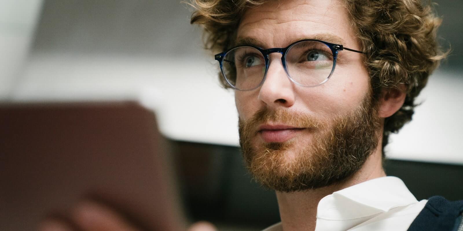 Pair of blue anti-light glasses NOOZ OPTICS worn by a bearded man