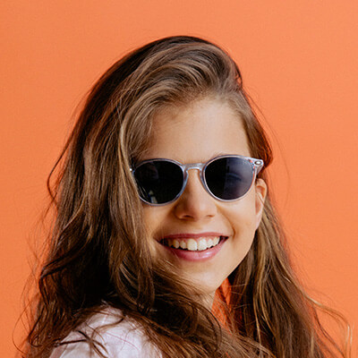 Paire de lunettes de soleil enfant portée par une fille souriante 