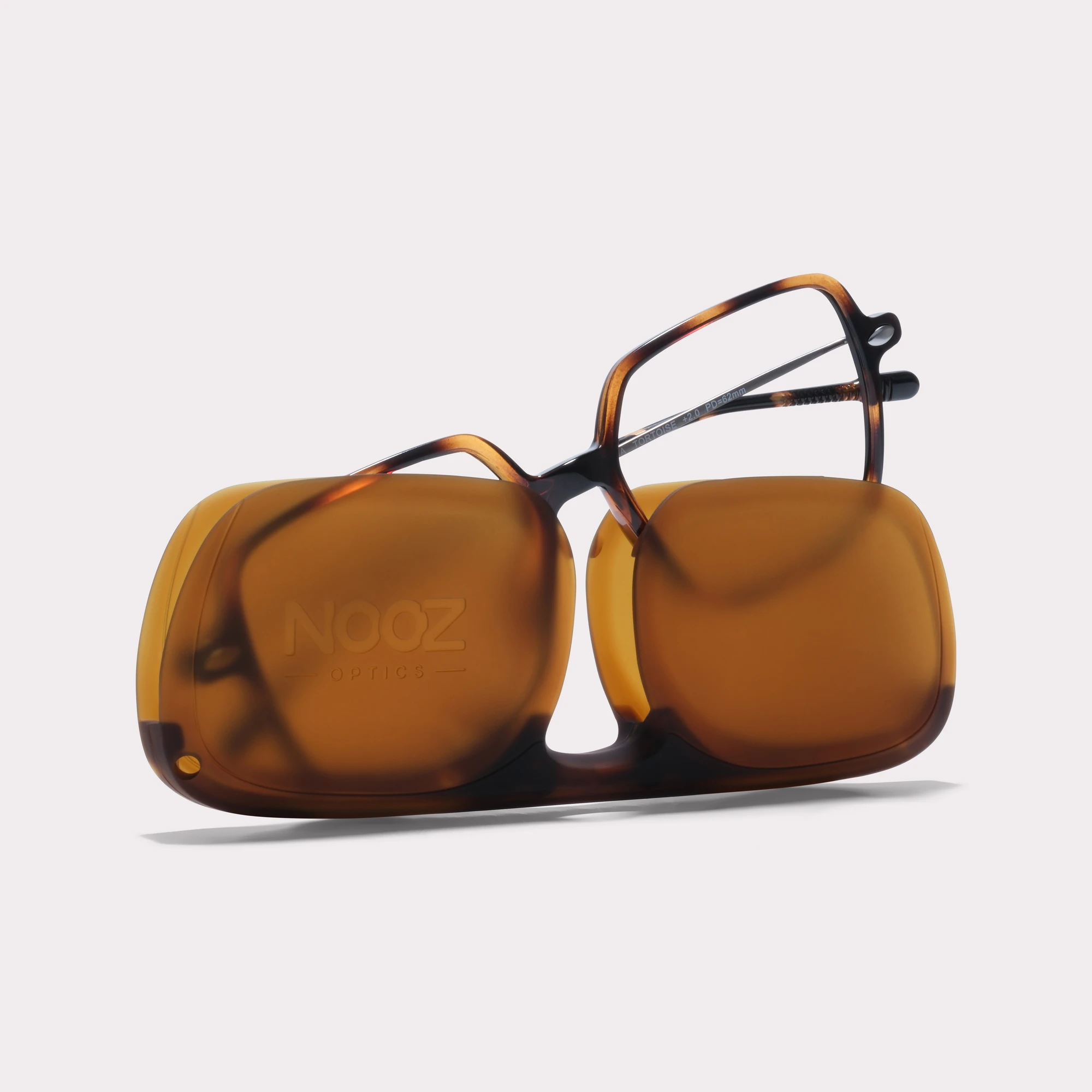 A pair of Lena Tortoise Reading glasses coming out of its case