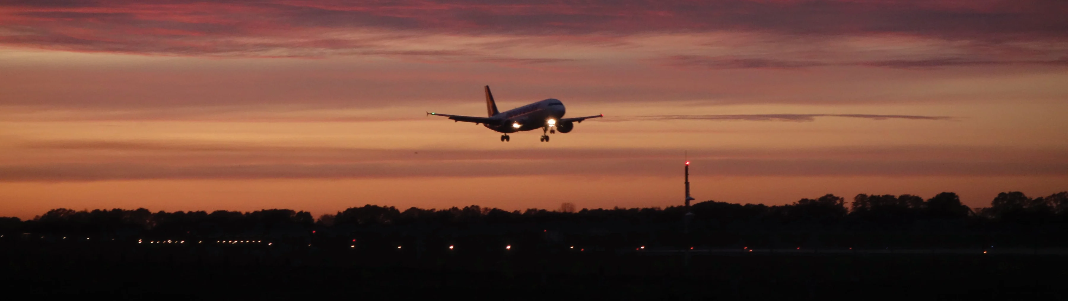 Fly Less Hero Image _ plane taking off at sunset
