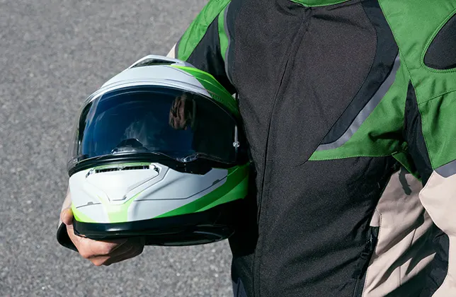 En motorcyklist bär hjälm.