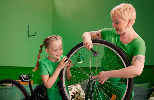 Nainen ja lapsi korjaavat pyörää.