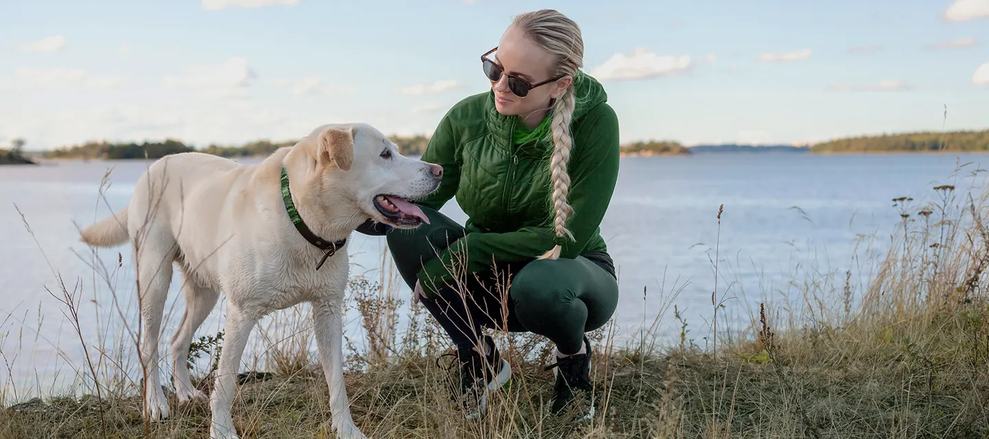 En kvinna och en hund utomhus.